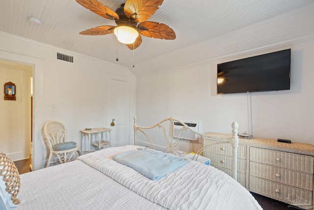 bedroom featuring lofted ceiling, crown molding, a wall mounted AC, dark hardwood / wood-style flooring, and ceiling fan