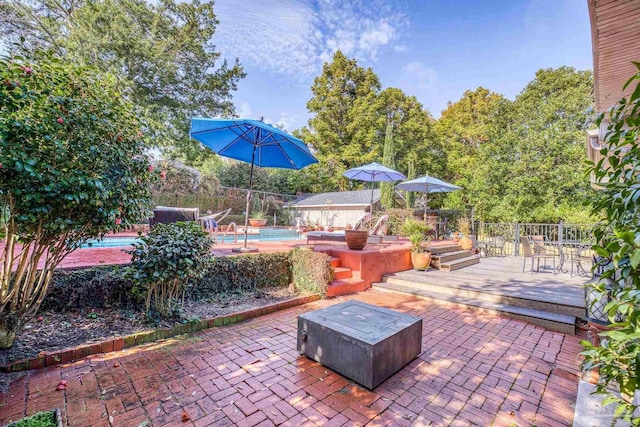 view of patio / terrace with a pool side deck and a fire pit