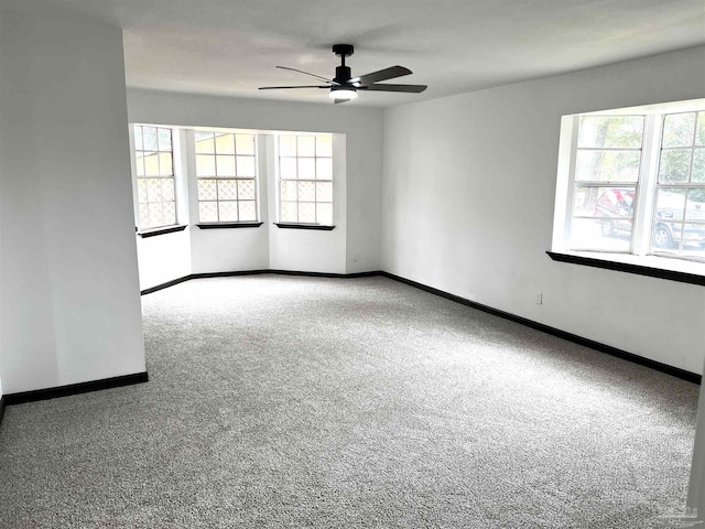 empty room with ceiling fan, carpet, and a healthy amount of sunlight