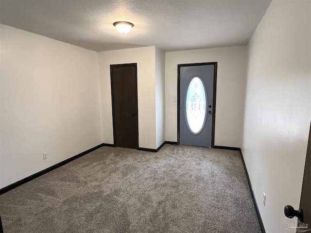 carpeted entryway with a textured ceiling