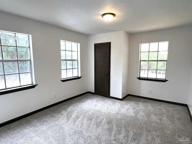 unfurnished bedroom featuring a textured ceiling and light colored carpet