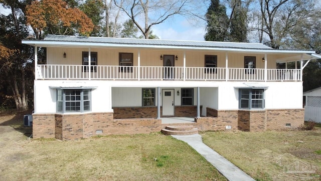 view of front facade with cooling unit, a porch, a balcony, and a front yard