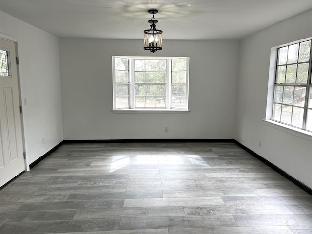 unfurnished dining area featuring a notable chandelier and light hardwood / wood-style flooring