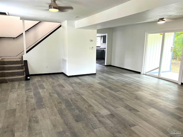 unfurnished living room featuring ceiling fan and hardwood / wood-style floors