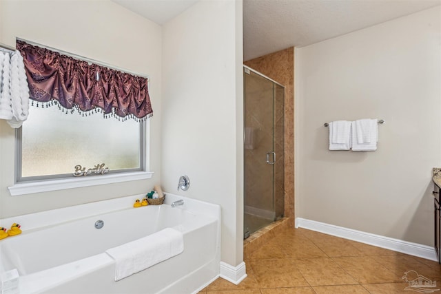 bathroom with tile patterned flooring, a shower stall, baseboards, a garden tub, and vanity