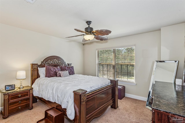 bedroom with light colored carpet, baseboards, and ceiling fan