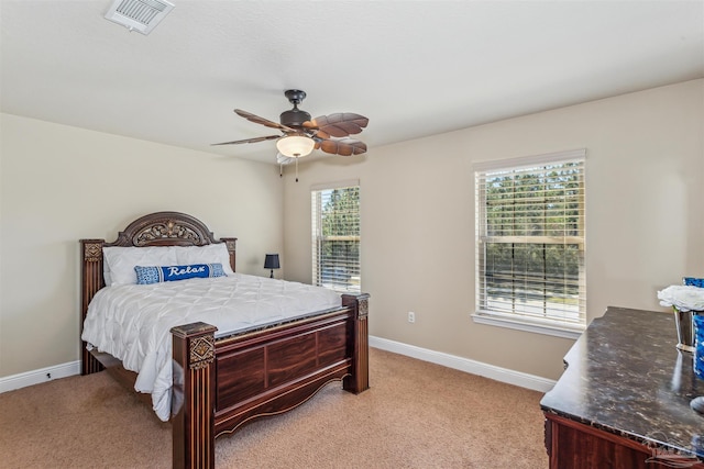 bedroom featuring multiple windows, visible vents, and light carpet