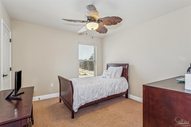 bedroom featuring baseboards, light colored carpet, and a ceiling fan