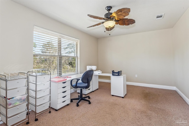 office space with visible vents, light colored carpet, baseboards, and ceiling fan