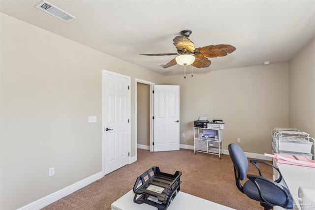 carpeted office space featuring baseboards, visible vents, and ceiling fan