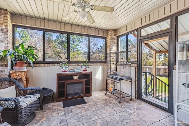 sunroom / solarium with wooden ceiling and a ceiling fan