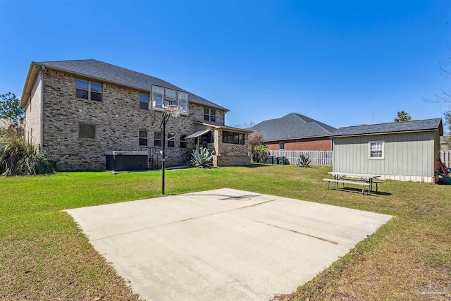 view of sport court with a yard, a storage shed, and fence