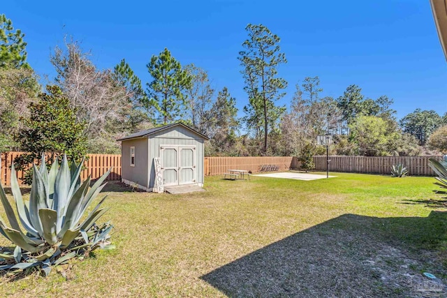 view of yard featuring an outdoor structure, a fenced backyard, a shed, and a patio