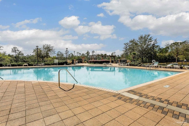 pool featuring fence and a patio area