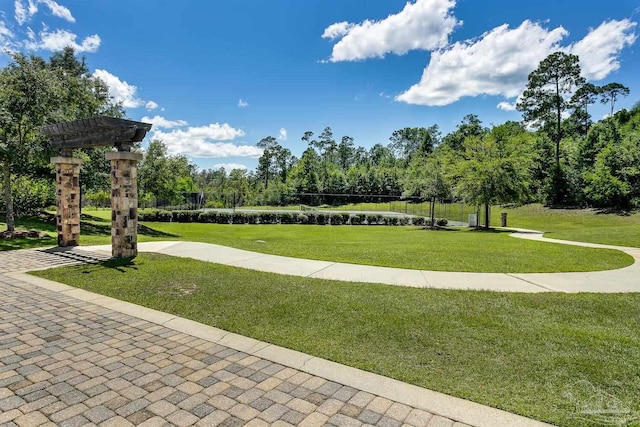 view of home's community featuring a lawn and a pergola