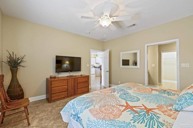 bedroom featuring visible vents, light tile patterned flooring, ceiling fan, a textured ceiling, and baseboards