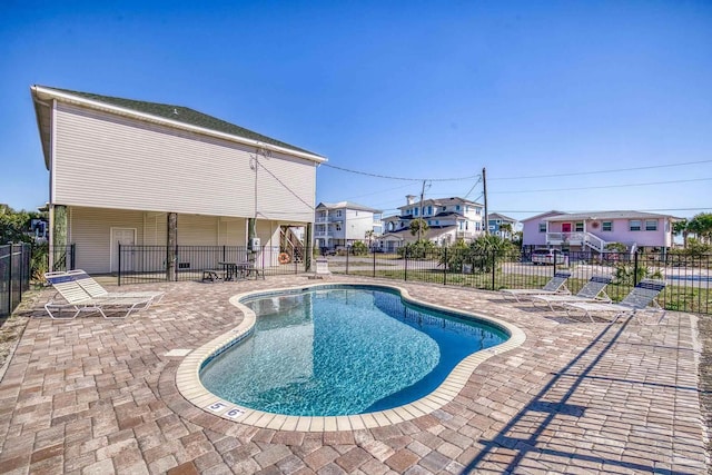 view of pool featuring a residential view, fence, a fenced in pool, and a patio