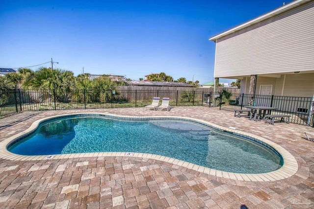 view of swimming pool featuring a patio, fence, and a fenced in pool