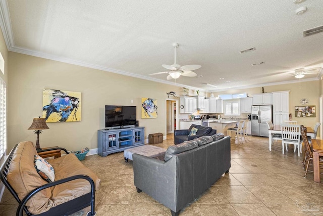 living area featuring a textured ceiling, visible vents, a ceiling fan, and ornamental molding