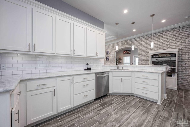 9074 Byrom Campbell Rd, Pace, FL 32571 - kitchen with dishwasher, a sink, white cabinets, a peninsula, and brick wall