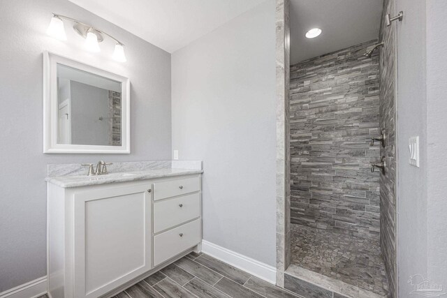 9074 Byrom Campbell Rd, Pace, FL 32571 - bathroom with baseboards, tiled shower, and vanity