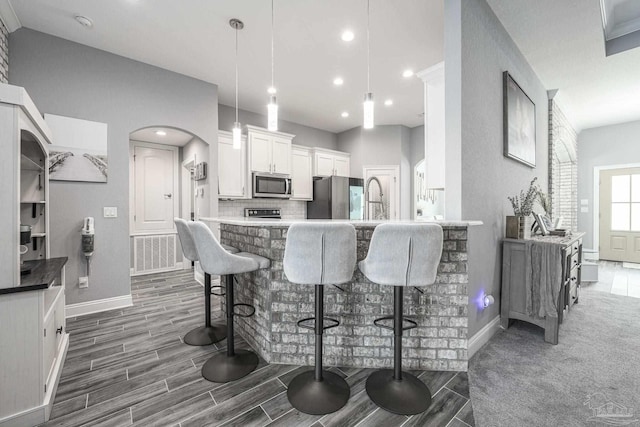 9074 Byrom Campbell Rd, Pace, FL 32571 - kitchen featuring stainless steel appliances, baseboards, a kitchen bar, dark wood-style floors, and recessed lighting