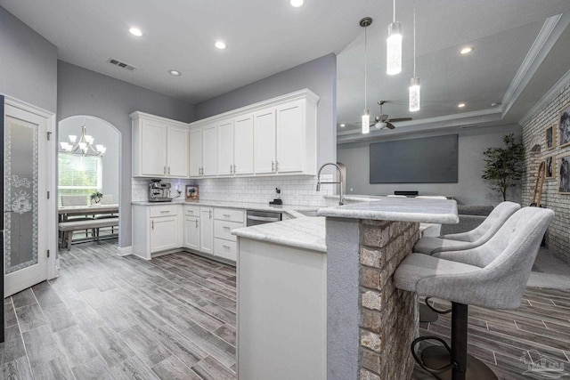 9074 Byrom Campbell Rd, Pace, FL 32571 - kitchen with a sink, a peninsula, white cabinetry, decorative backsplash, and recessed lighting