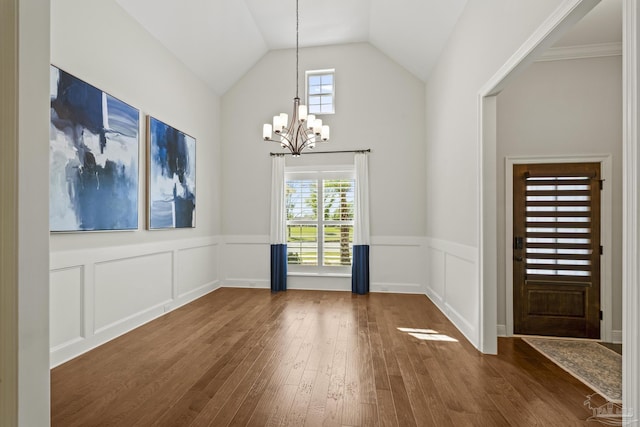 unfurnished dining area featuring plenty of natural light, an inviting chandelier, and dark wood-style flooring