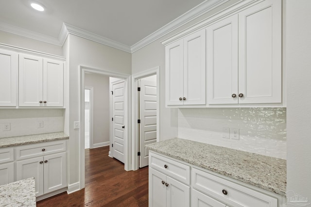 kitchen featuring crown molding, tasteful backsplash, dark wood-type flooring, and white cabinetry