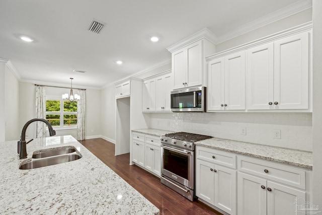 kitchen featuring a sink, appliances with stainless steel finishes, white cabinets, ornamental molding, and visible vents