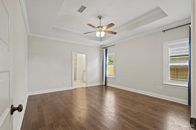 unfurnished room with hardwood / wood-style floors, a tray ceiling, visible vents, ornamental molding, and ceiling fan