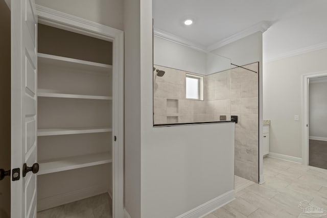 bathroom featuring walk in shower, a spacious closet, and crown molding