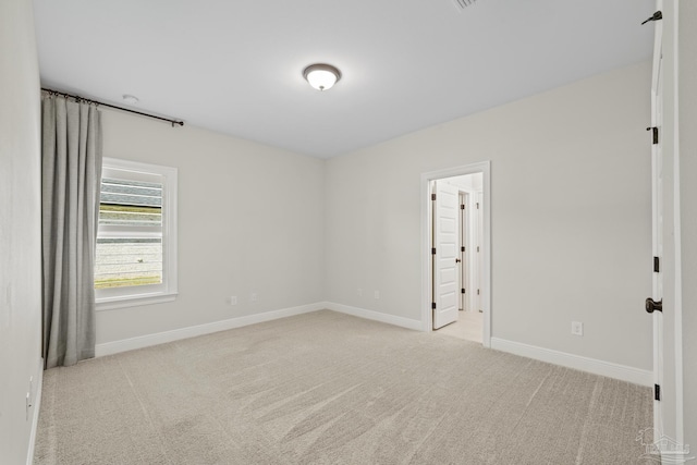 unfurnished room featuring carpet flooring and baseboards