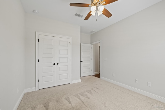 unfurnished bedroom featuring a ceiling fan, a closet, carpet, baseboards, and visible vents