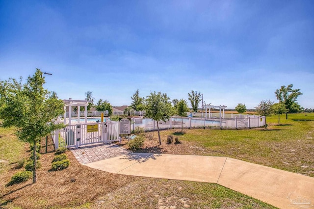 view of yard featuring a gate, a community pool, and fence