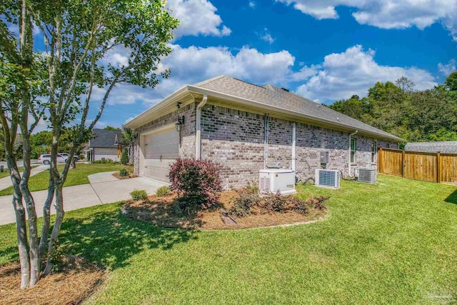 view of side of property with brick siding, driveway, central air condition unit, and a lawn