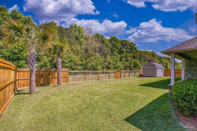 view of yard featuring an outbuilding, a shed, and a fenced backyard