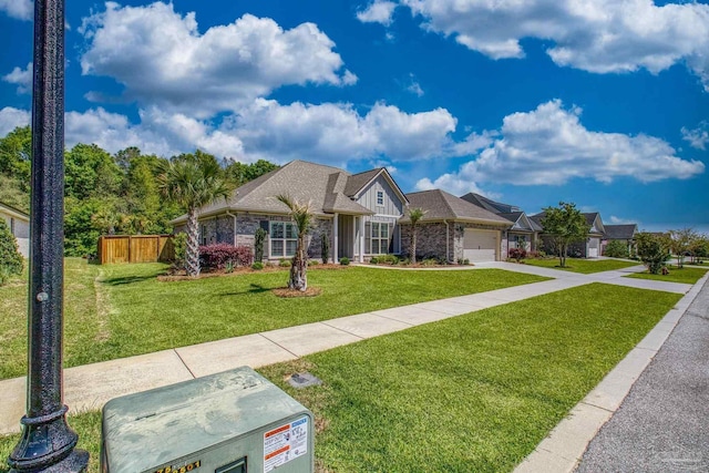 view of front facade with fence, a front lawn, concrete driveway, an attached garage, and brick siding