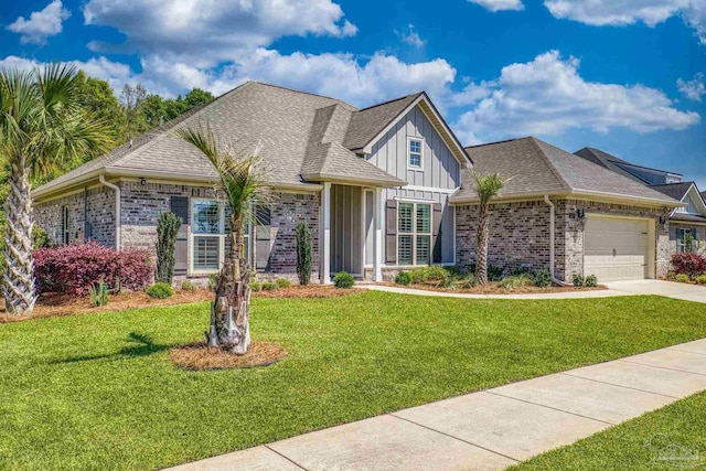 craftsman inspired home featuring board and batten siding, an attached garage, a front yard, and brick siding