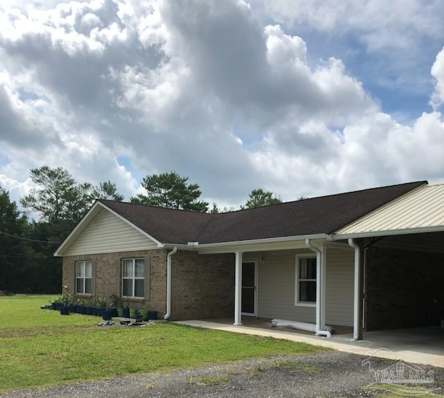 ranch-style home featuring a front lawn and a carport