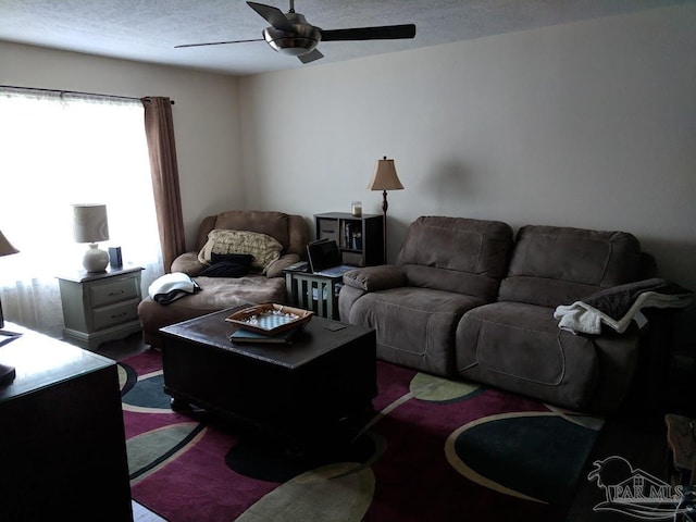 living room featuring a textured ceiling and ceiling fan