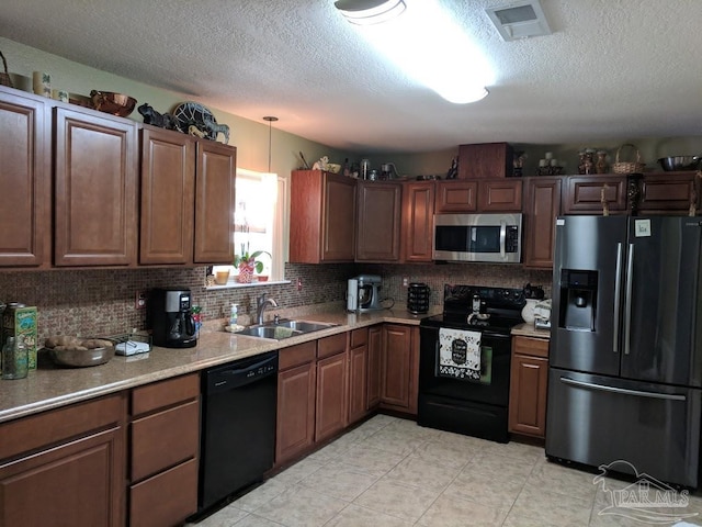 kitchen featuring sink, tasteful backsplash, black appliances, and light tile patterned floors