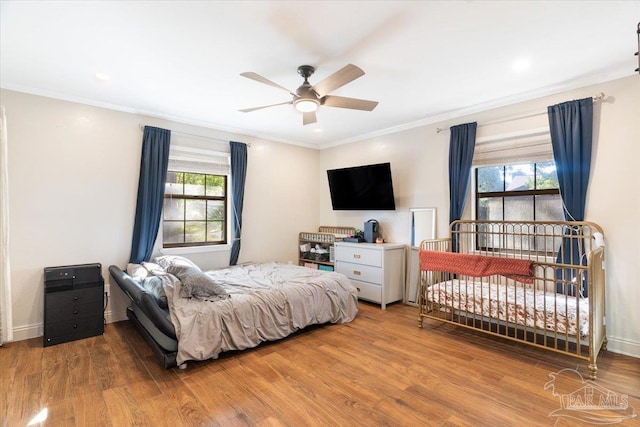 bedroom featuring ceiling fan, wood-type flooring, and multiple windows