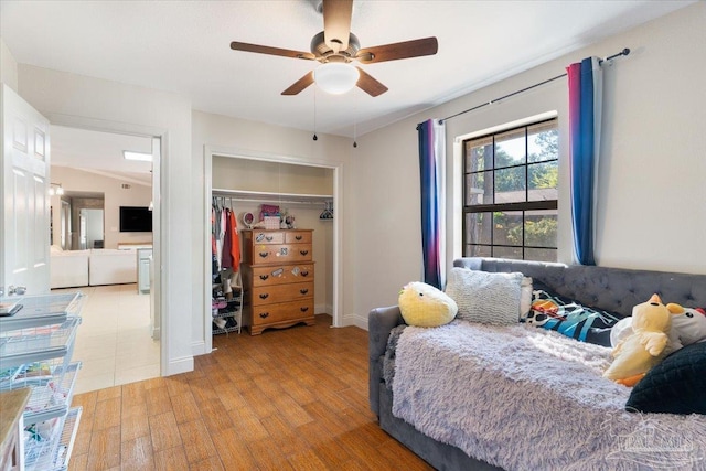 bedroom with ceiling fan, a closet, and light hardwood / wood-style flooring