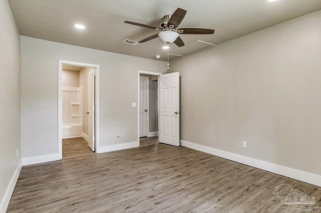 unfurnished bedroom with ensuite bath, ceiling fan, hardwood / wood-style floors, and a spacious closet