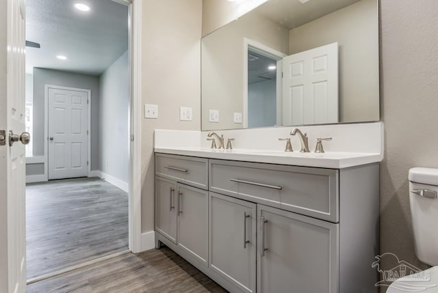 bathroom with vanity, wood-type flooring, and toilet