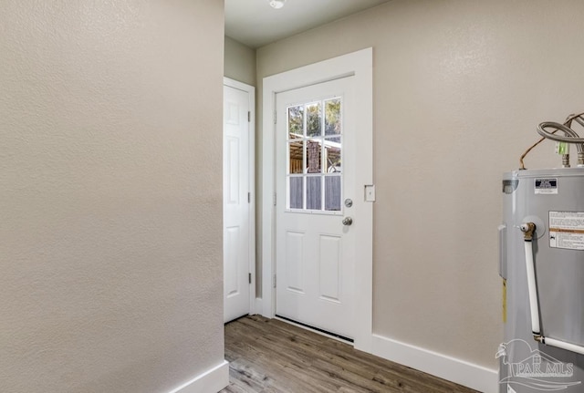 doorway with hardwood / wood-style floors and water heater