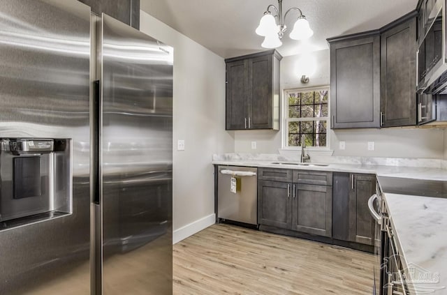 kitchen with pendant lighting, sink, light hardwood / wood-style floors, dark brown cabinetry, and stainless steel appliances