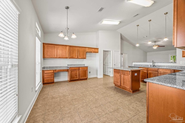 5649 Cane Syrup Cir, Pace, FL 32571 - kitchen with light stone countertops, hanging light fixtures, brown cabinetry, and a sink