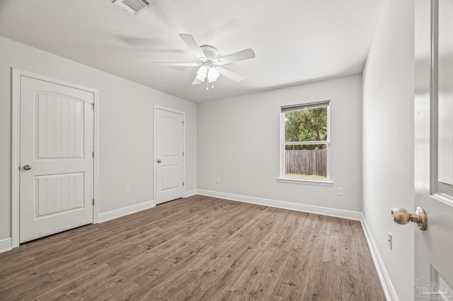 5649 Cane Syrup Cir, Pace, FL 32571 - unfurnished bedroom with baseboards, ceiling fan, wood finished floors, and visible vents